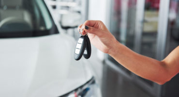 Passing car keys. Cropped closeup of a car dealer holding out car keys to the camera copyspace car dealership salon manager salesman selling buying giving owner profession purchase vehicle concept.